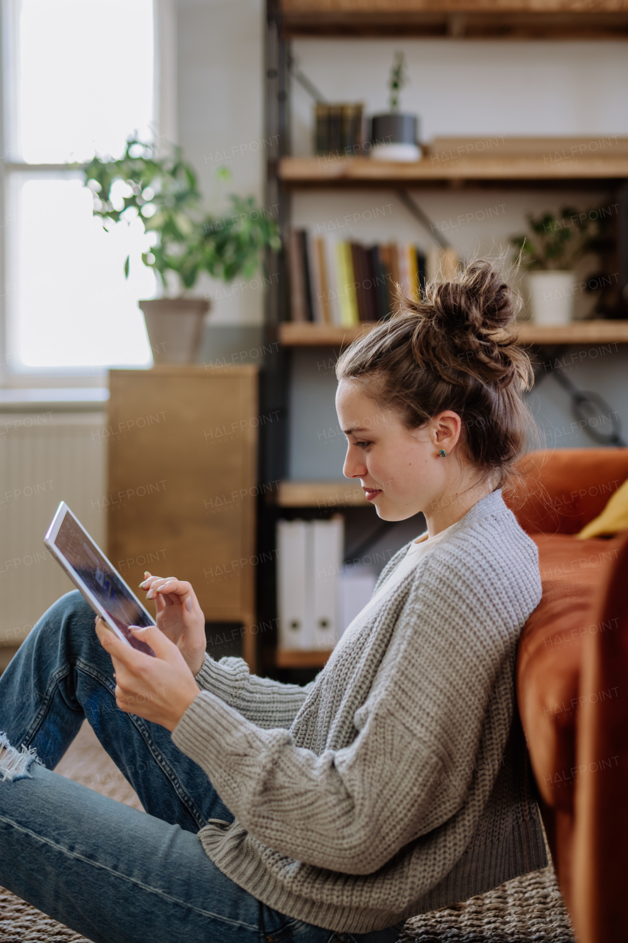 Young woman with digital tablet resting in the apartment.