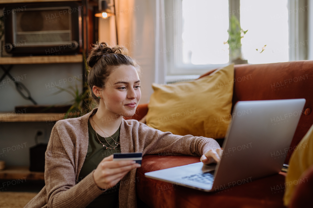 Young woman shopping online in the apartment.