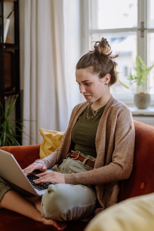 Young woman with digital tablet resting in the apartment.