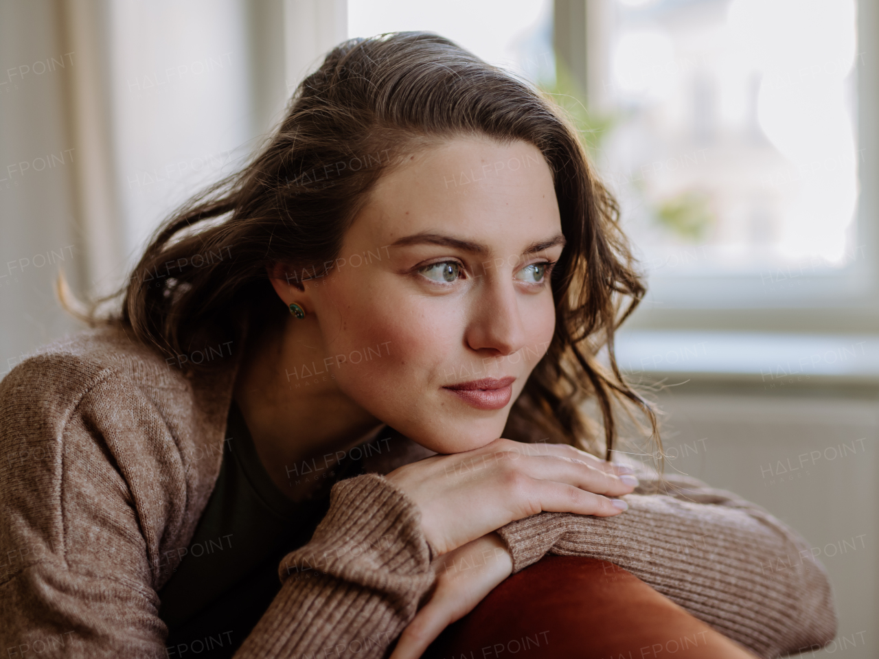 Portrait of young pensive woman, in the apartment.