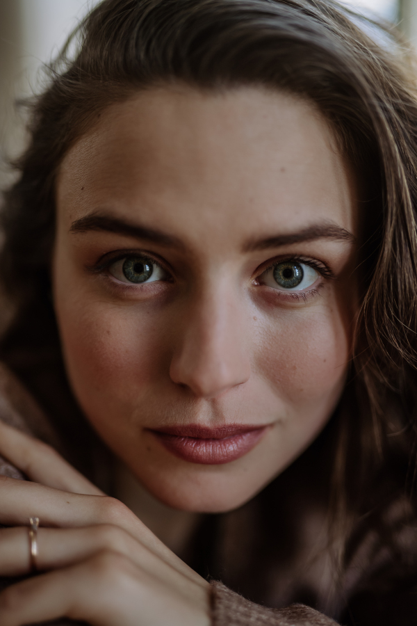 Portrait of young pensive woman, in the apartment.