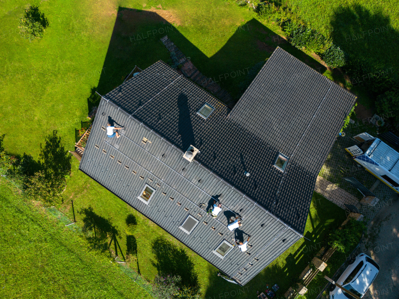 Top view of men worker installing solar photovoltaic panels on a roof, alternative energy, saving resources and sustainable lifestyle concept.