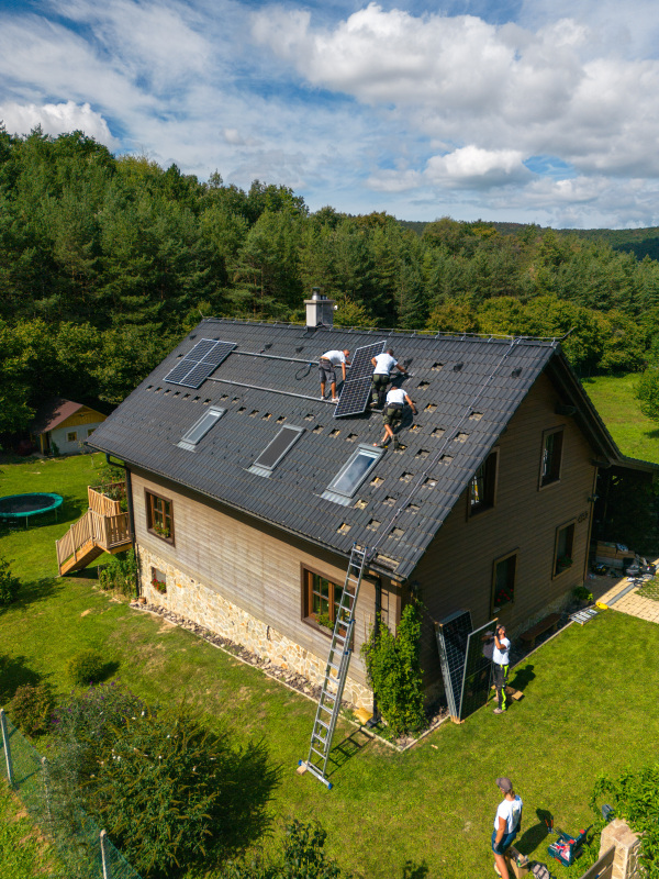 Men worker installing solar photovoltaic panels on a roof, alternative energy, saving resources and sustainable lifestyle concept.