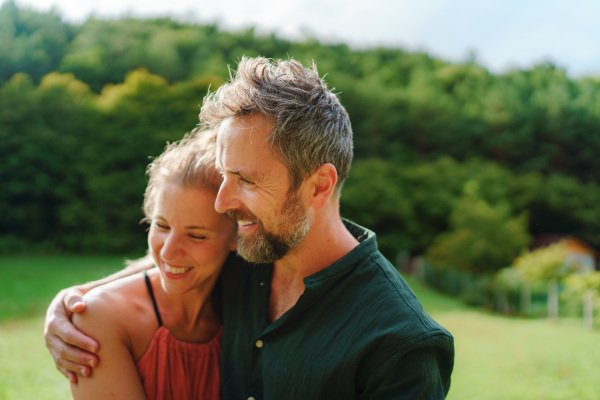 Close-up of happy couple looking and dreaming about future, outdoor at meadow.