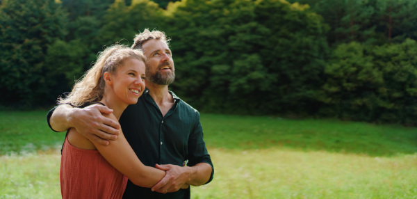 Close-up of happy couple looking and dreaming about future, outdoor at meadow.