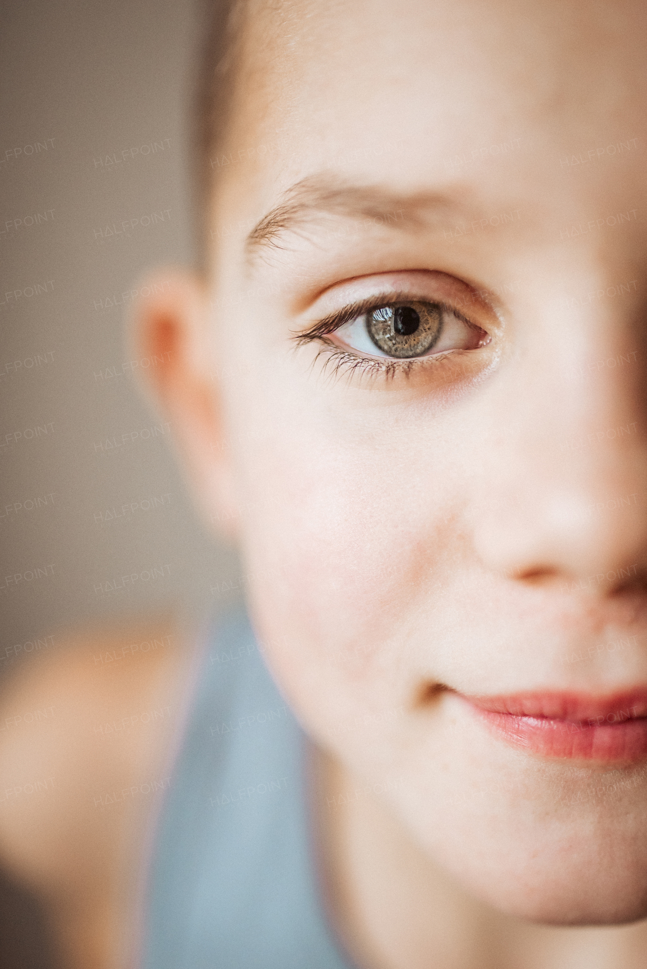 Portrait, half face of a smiling boy looking at the camera. Beautiful gray eyes.