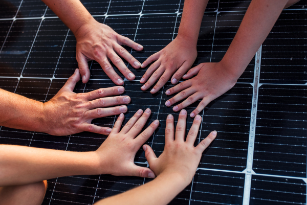 Close up of hands on solar panel. Rooftop solar or photovoltaic system. Sustainable future for next generation.