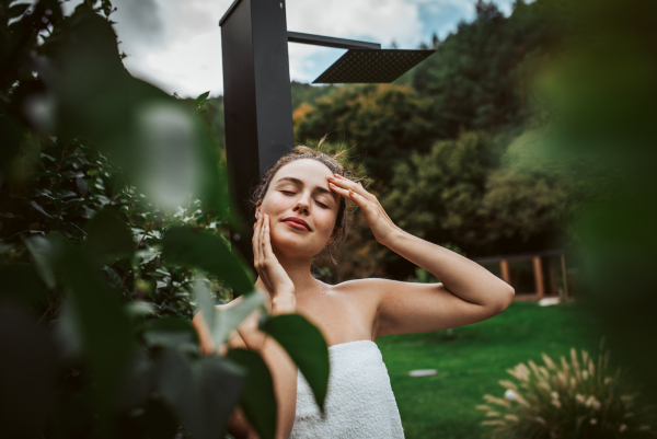 Beautiful woman resting in the garden after using home sauna. Woman taking care of her body and mind, wellness routine