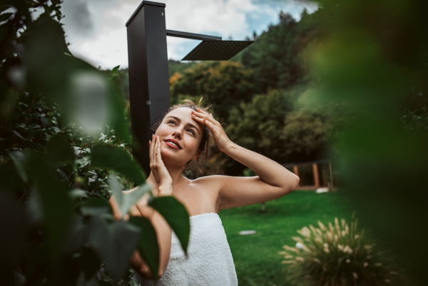 Beautiful woman resting in the garden after using home sauna. Woman taking care of her body and mind, wellness routine