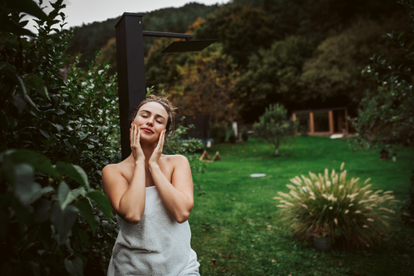 Beautiful woman resting in the garden after using home sauna. Woman taking care of her body and mind, wellness routine