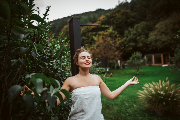 Beautiful woman meditating outdoor in the garden.. Woman taking care of her body and mind, wellness routine