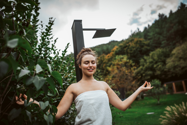 Beautiful woman resting in the garden after using home sauna. Woman taking care of her body and mind, wellness routine