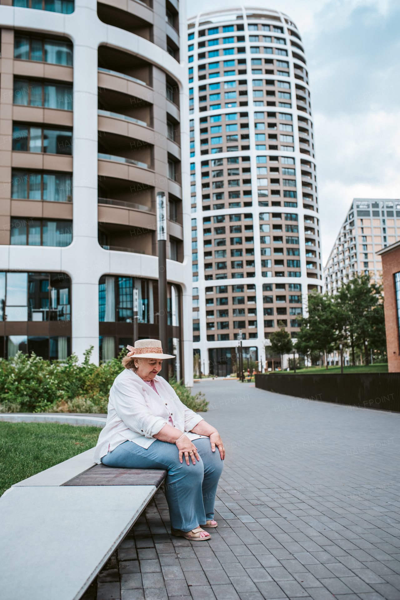 Elderly woman sitting on bench, taking break after long walk. Senior woman running errands, feeling fatigued.