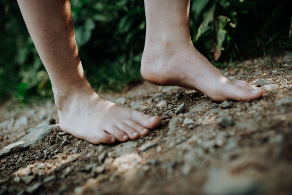 Close-up of barefoot legs walking in the nature. Concept of healthy feet.