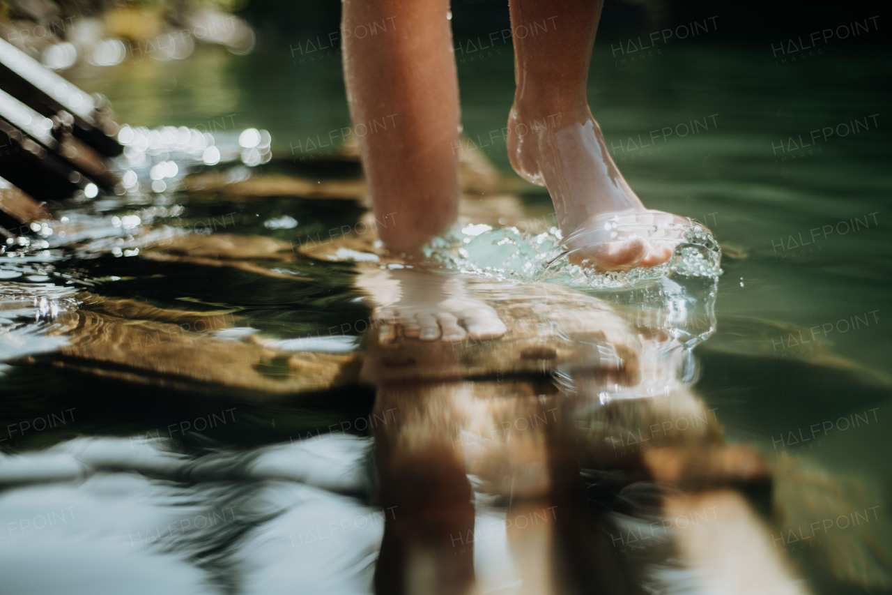 Close-up of barefoot legs walking in the lake shore. Concept of healthy feet.