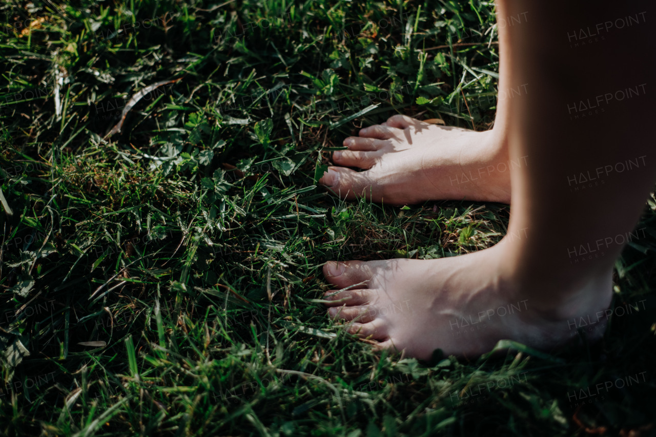 Close-up of barefoot legs standing in the grass. Concept of healthy feet.