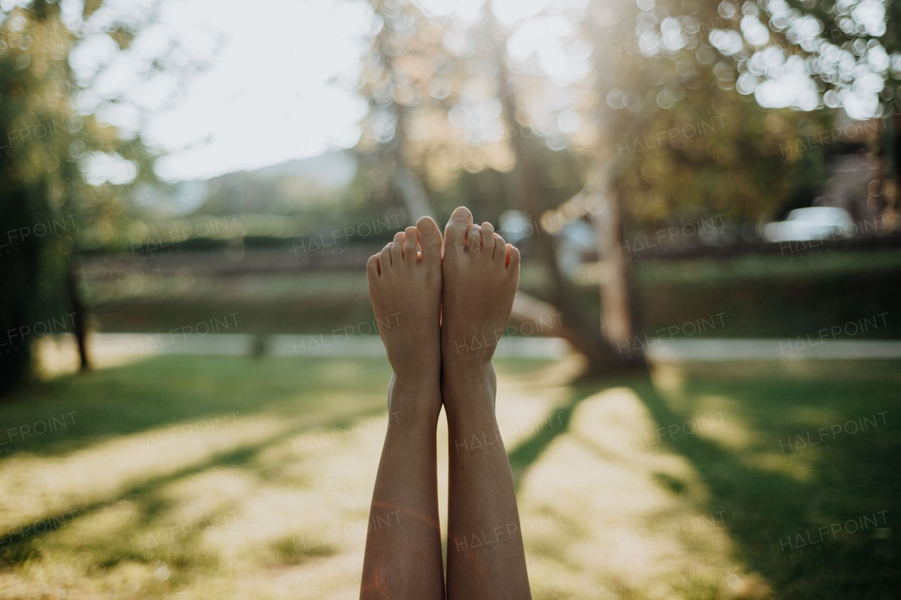 Close-up of barefoot legs up,resting at lawn. Concept of healthy feet.