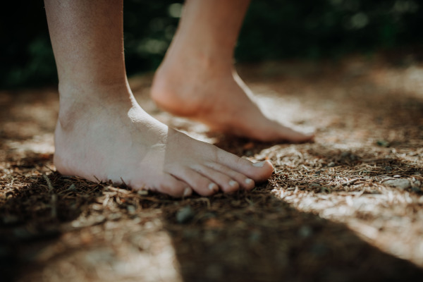 Close-up of barefoot legs walking in the nature. Concept of healthy feet.