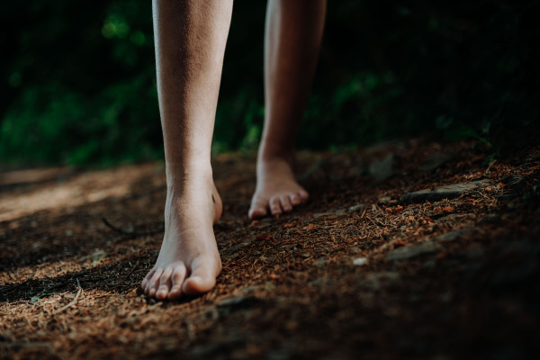 Close-up of barefoot legs walking in the nature. Concept of healthy feet.