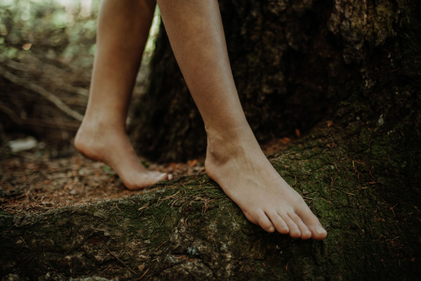 Close-up of barefoot legs walking in the nature. Concept of healthy feet.