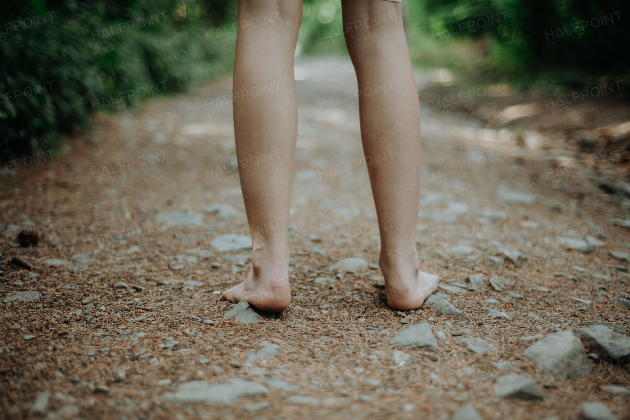 Rear view of barefoot legs walking in the forest. Concept of healthy feet.