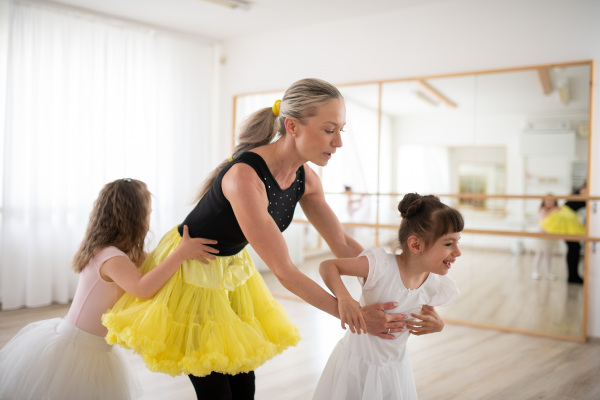 Little disabled girls learning ballet with dance lecteur in a ballet studio.