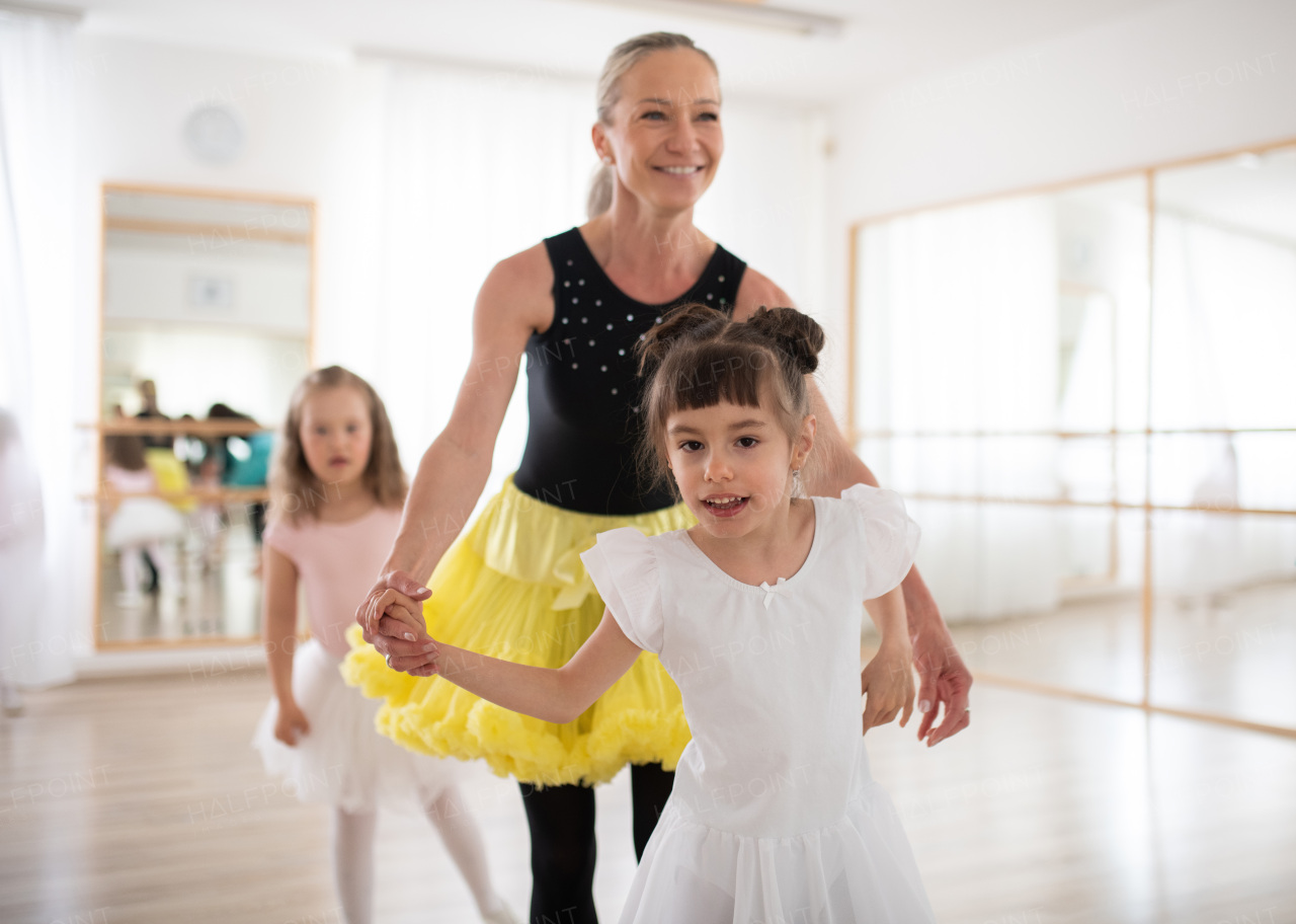 Little disabled girls learning ballet with dance lecteur in a ballet studio.