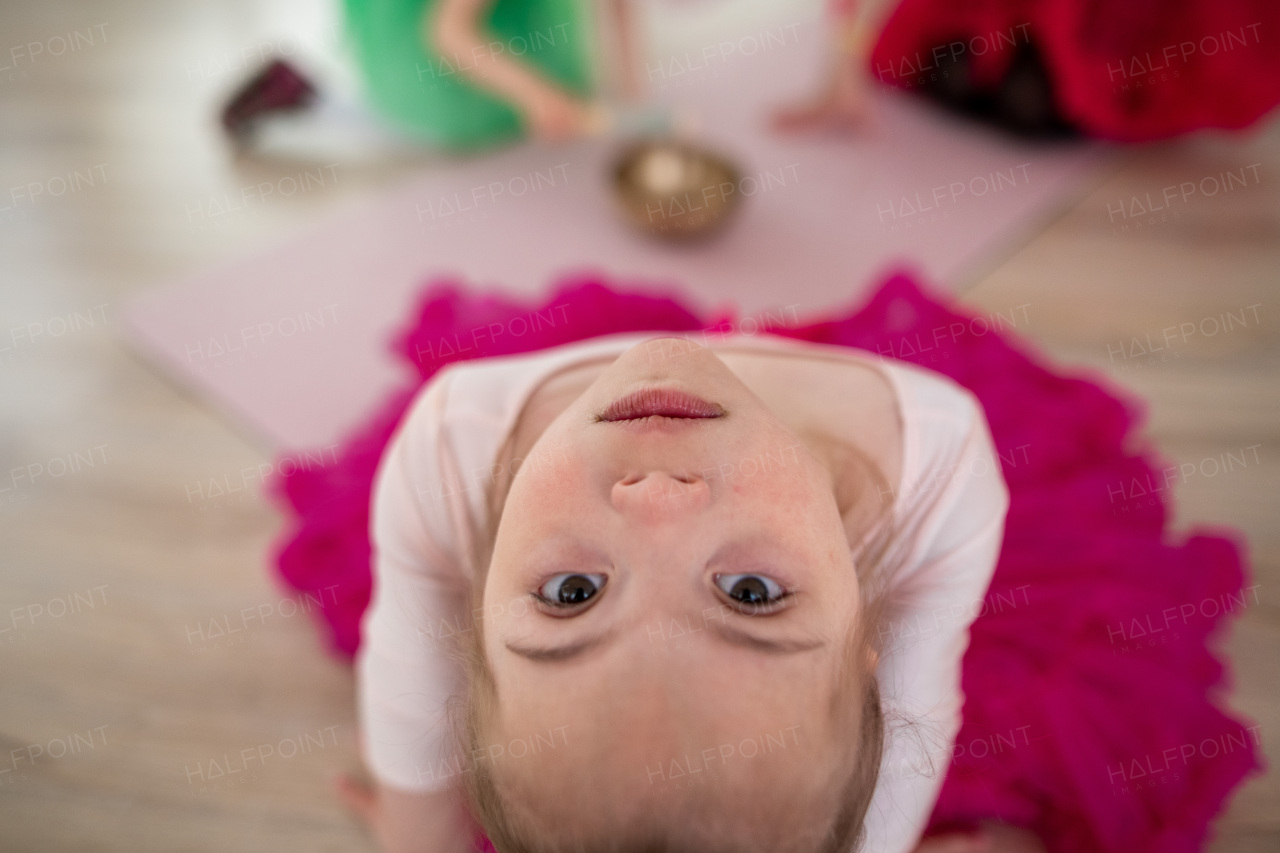 High angle view of little girl with down syndrome at a ballet class in dance studio. Concept of integration and education of disabled children.