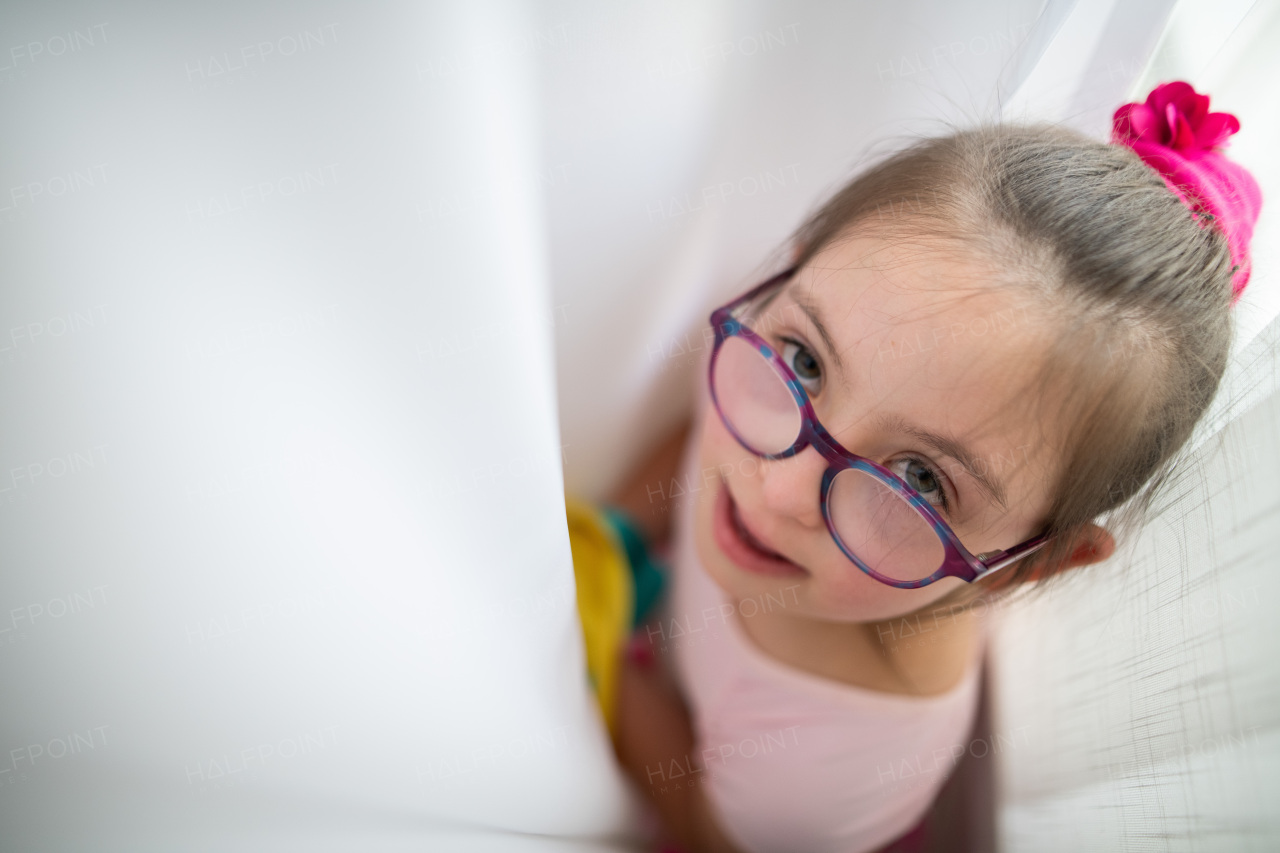 High angle view of little girl with down syndrome at a ballet class in dance studio. Concept of integration and education of disabled children.