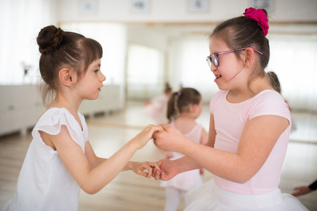 Little disabled girls dancing together in a ballet school studio. Concept od integration and education disabled children.