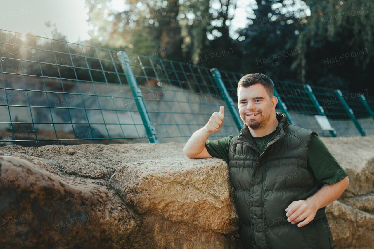 Portrait of caretaker with down syndrome in a zoo. Concept of integration people with disabilities into society.