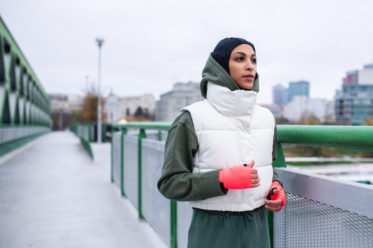 Young muslim woman running outdoor in a city.