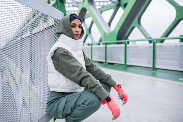 Young muslim woman having break during morning run.