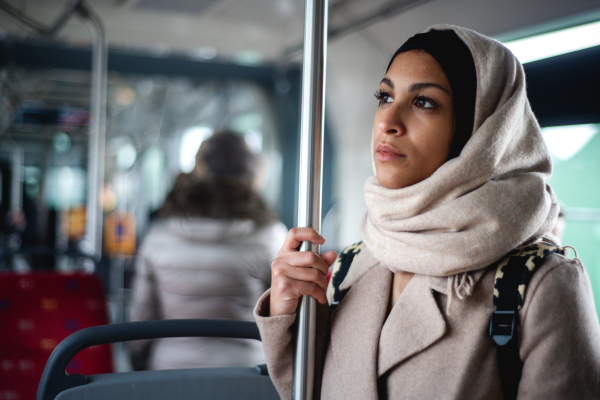 Young muslim woman traveling by a bus.