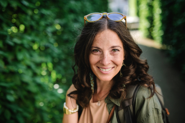 A woman candid portrait from park. Young urban female smiling looking at camera.