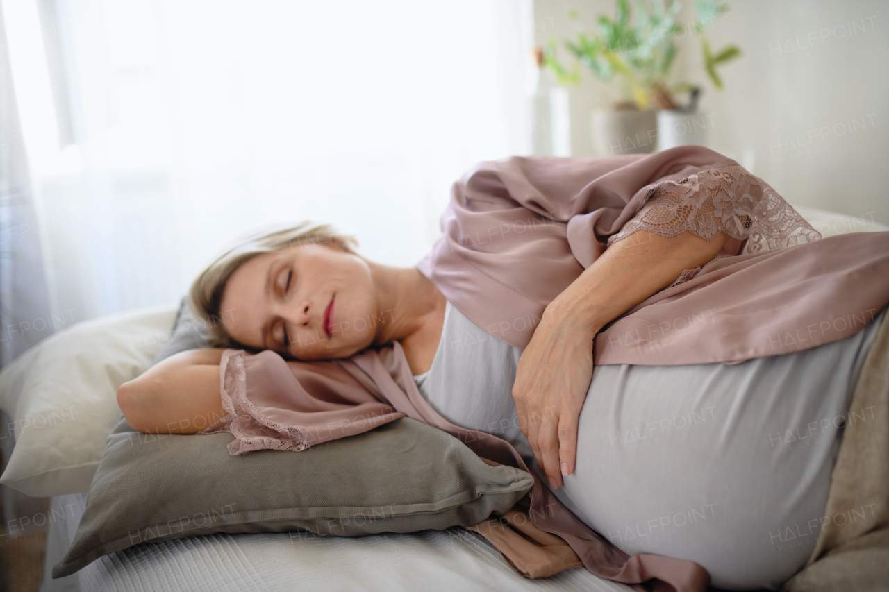 Pregnant woman sleeping and resting in a bed.