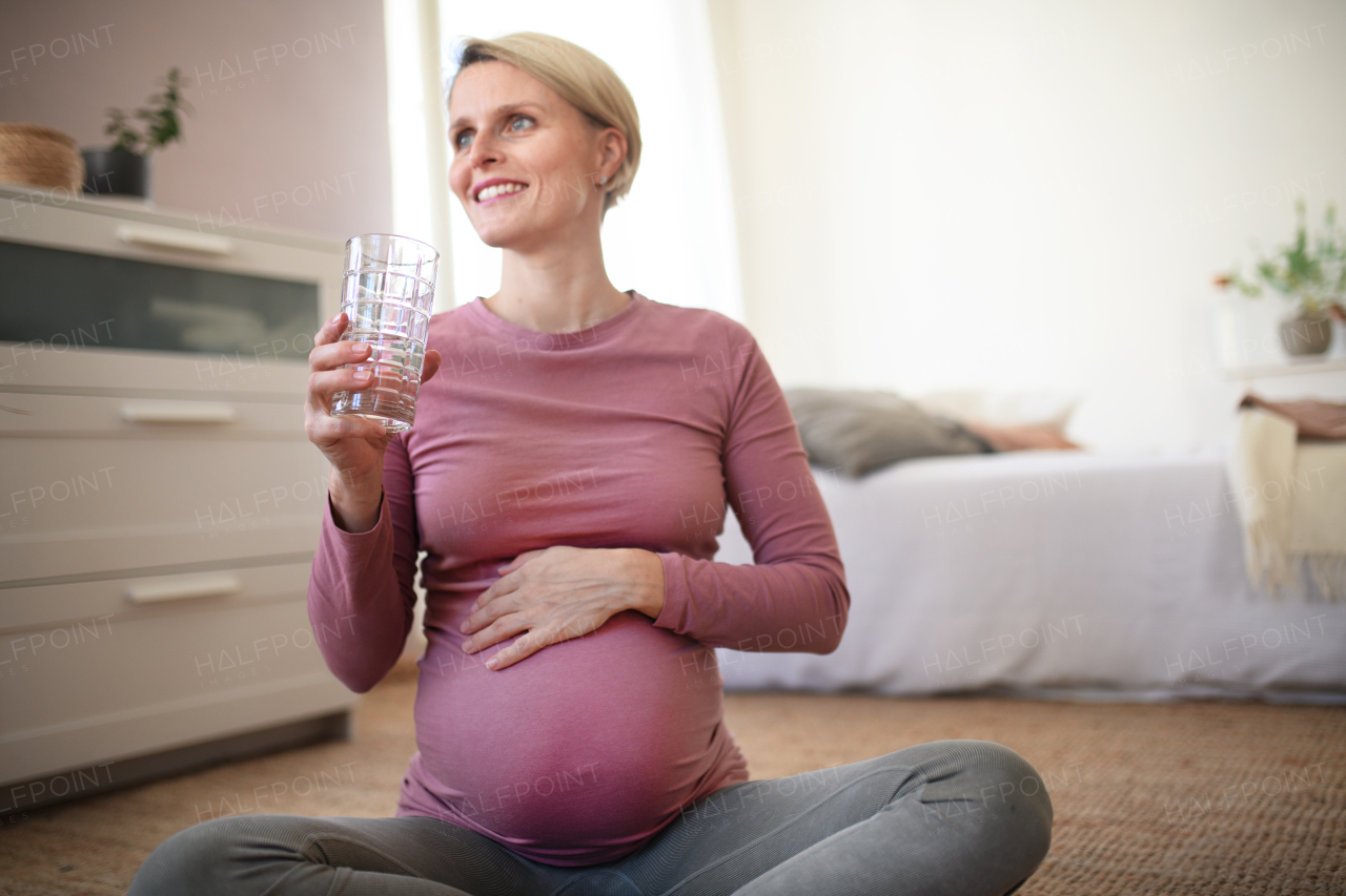 Pregnant woman drinking water. Healthy lifestyle and morning routine in pregnancy, concpet.