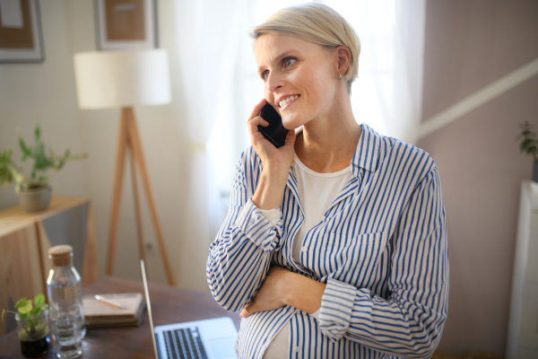 Pregnant woman having home office, calling.