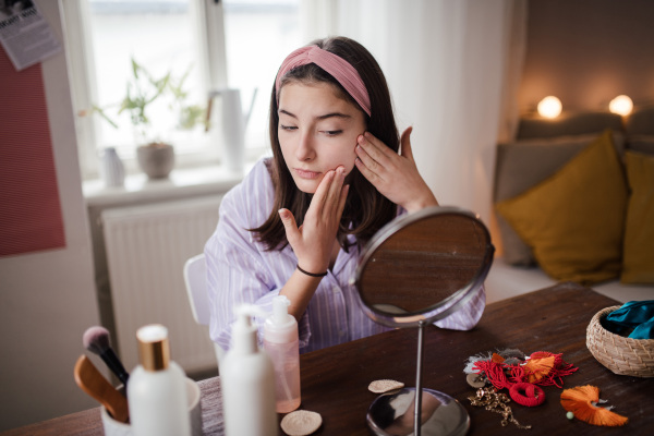 Teenage girl doing her skin care routine in the room.