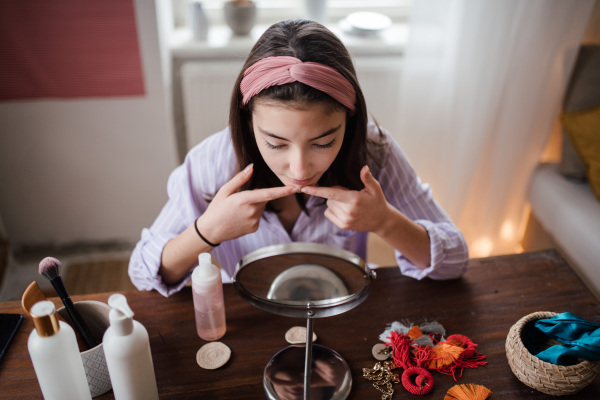 Teenage girl doing her skin care routine in the room.