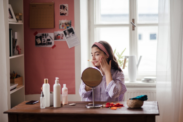 Teenage girl doing her skin care routine in the room.