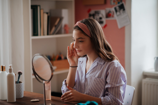 Teenage girl doing her skin care routine in the room.