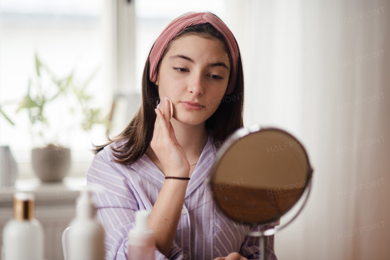 Teenage girl doing her skin care routine in the room.