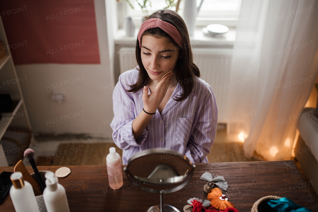 Teenage girl doing her skin care routine in the room.