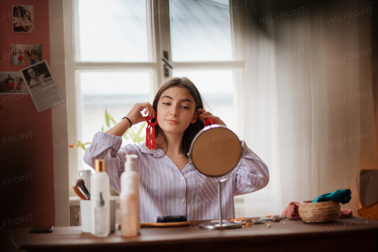 Teenage girl doing her skin care routine and getting ready before going out in her room.