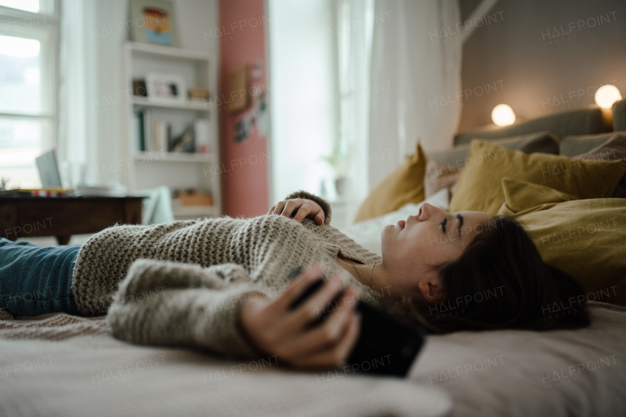 Young teenage girl with smartphone in a room.