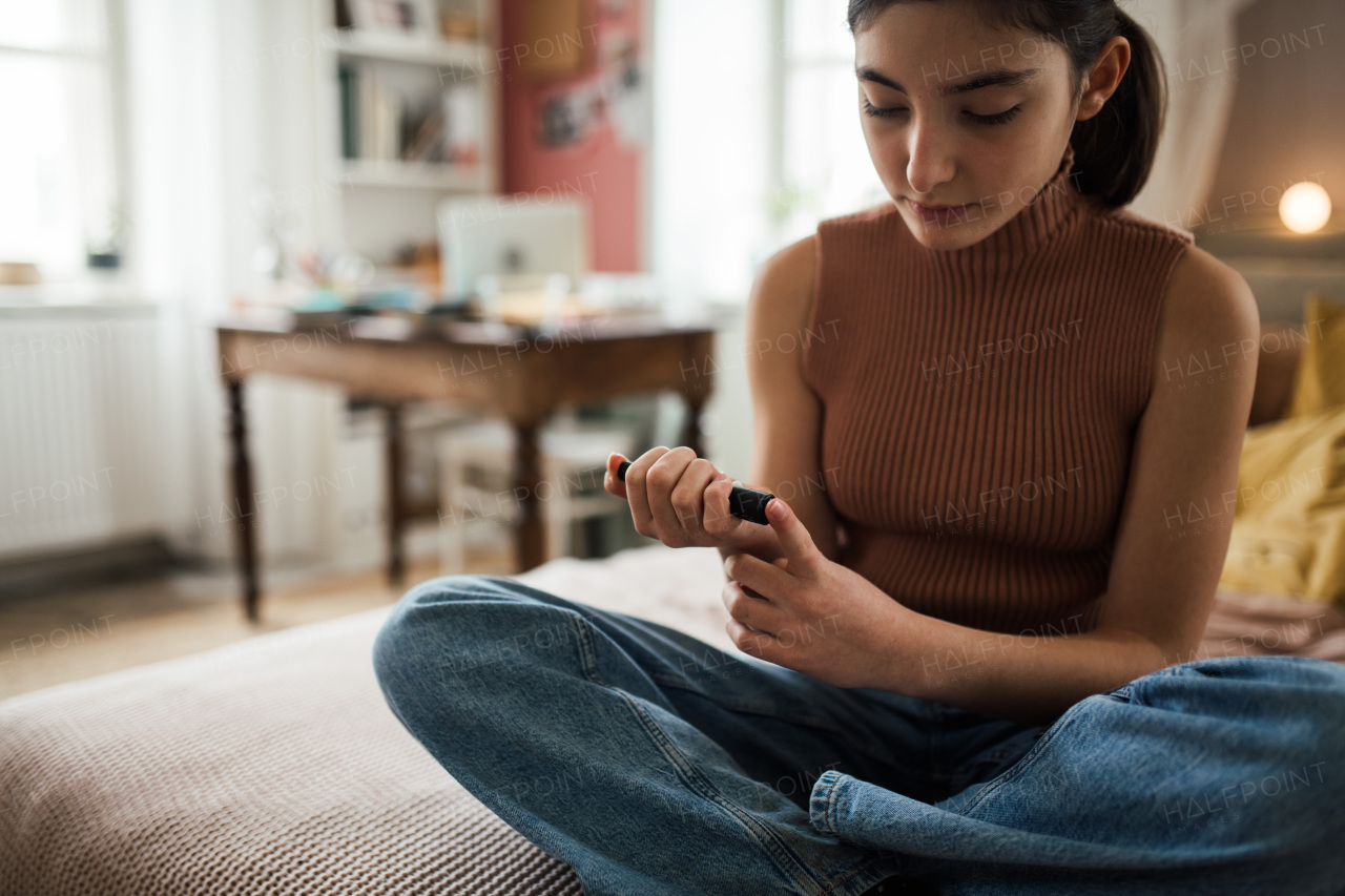 Young teenage girl applicating insulin with insulin pen.