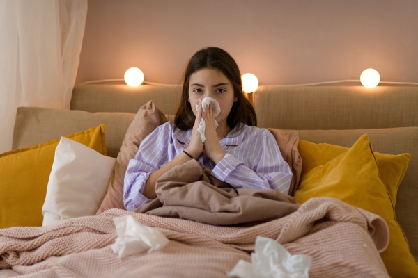 Sick teenage girl laying in the bed.