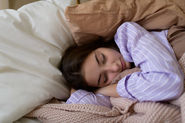 Close-up of teenage girl sleeping in the bed.