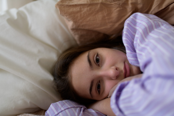 Close-up of teenage girl lying in the bed.